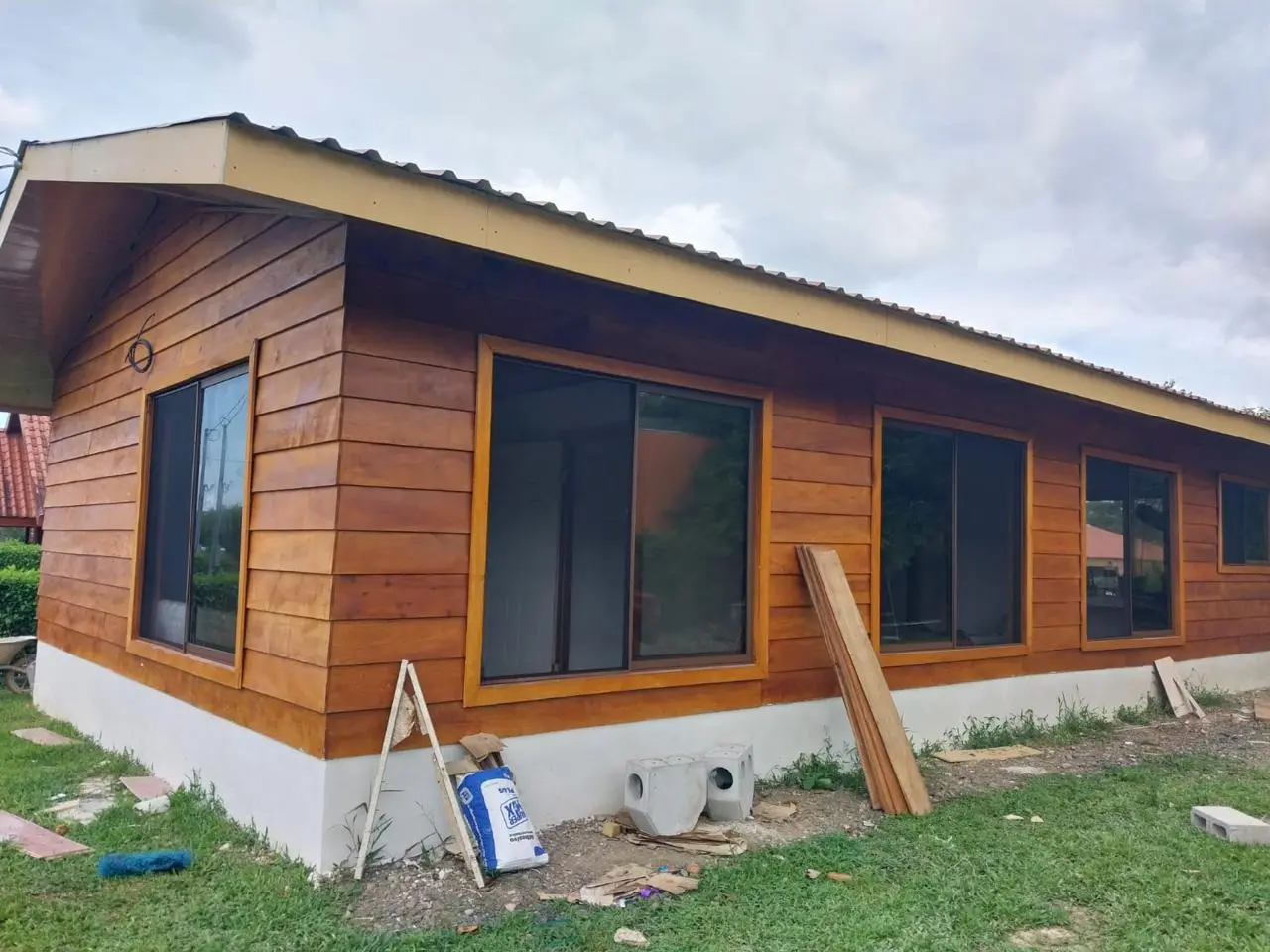 Exterior de casa de madera con ventanas panorámicas construida por ConstruHomesCR en San Carlos